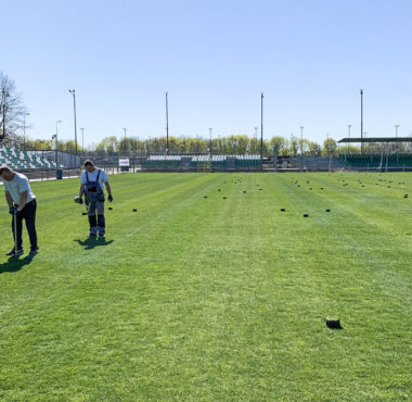 Pracownicy firmy Magmar prowadzą prace regeneracyjne murawy na stadionie Warty Poznań